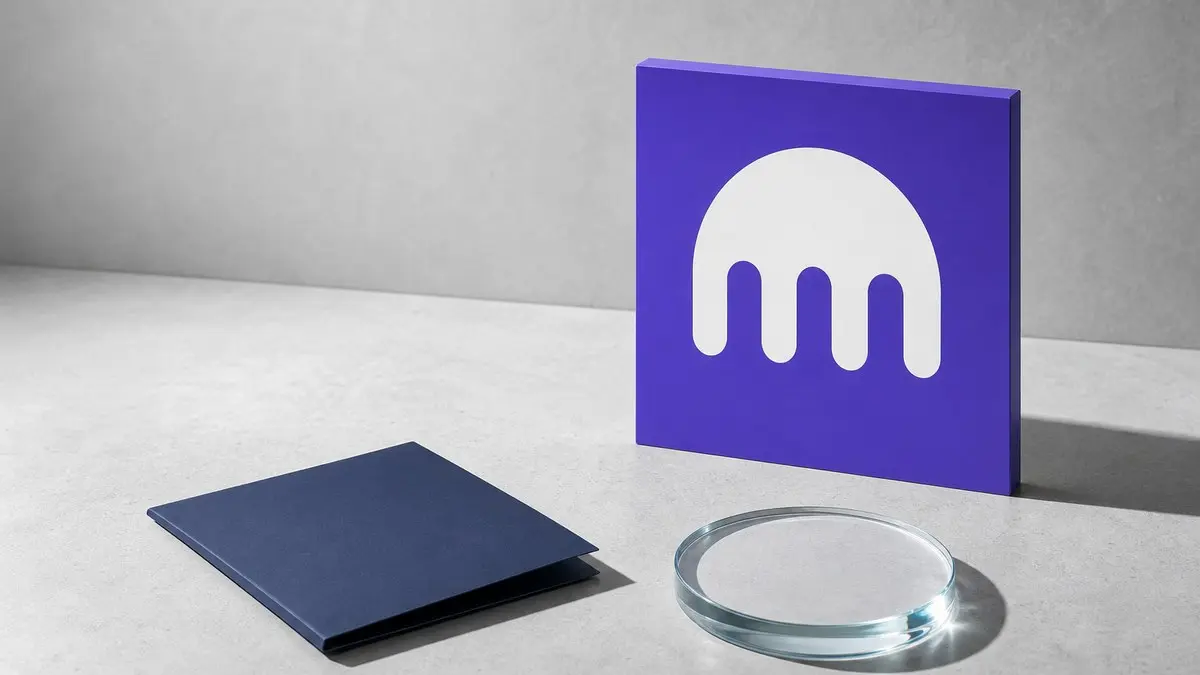 Auf heller Steinfläche steht ein violettes Schild mit dem weißen Kraken-Zeichen, davor liegen eine schlichte dunkelblaue Mappe und eine glatte Glasscheibe.