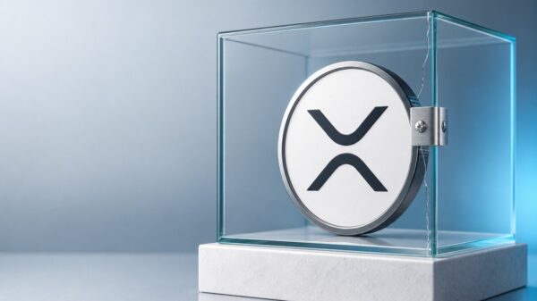 Große XRP-Münze mit silbernem Rand in einem Glaswürfel auf einem weißen Steinsockel, eine gerissene Kante des Glases ist mit einer verschraubten Stahlklammer geschlossen.